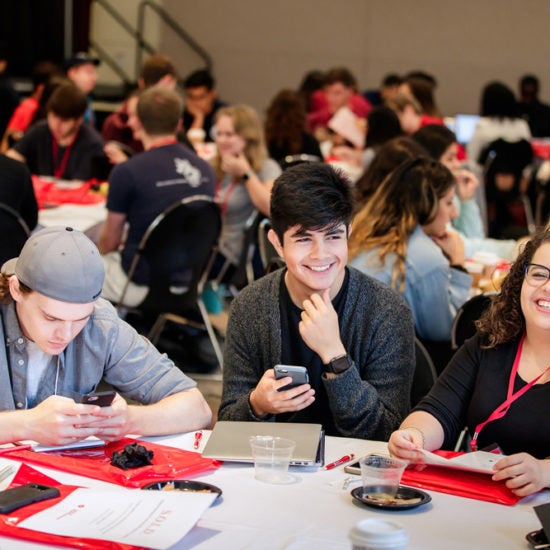 Students sitting at table, smiling